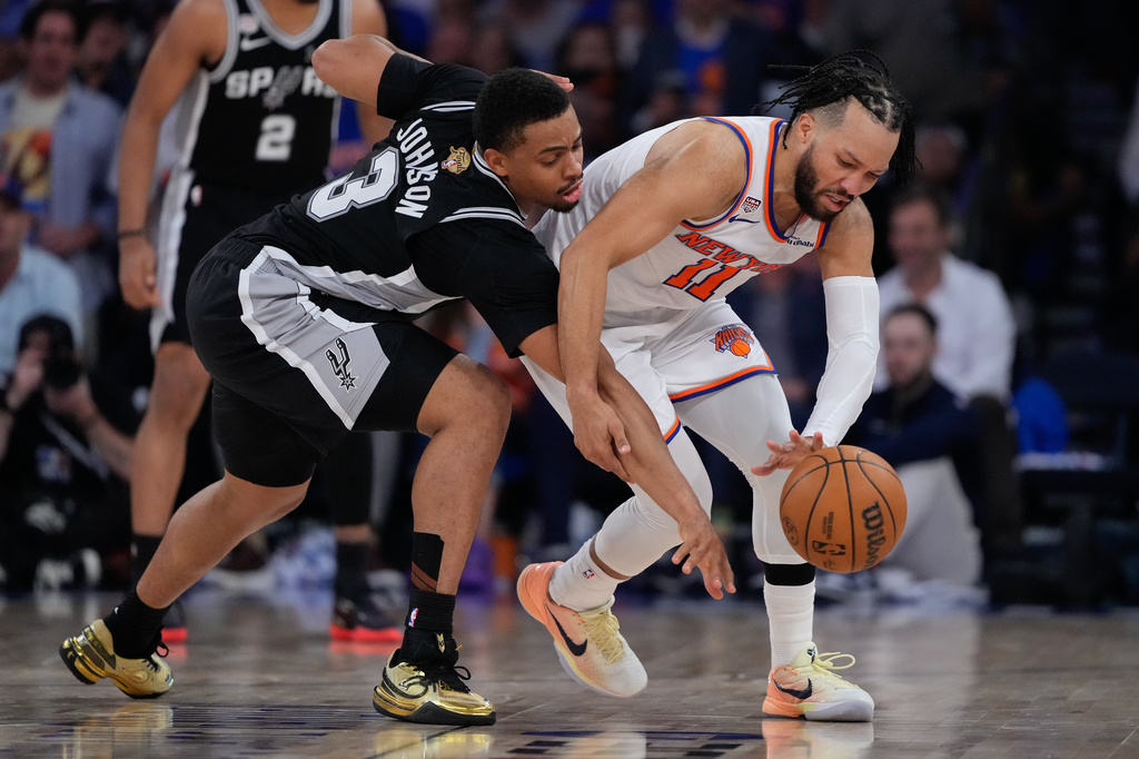 New York Knicks guard Jalen Brunson (11) and San Antonio Spurs forward Keldon Johnson (3) battle for the ball during the second half of Game 4 of the NBA Finals basketball series, Wednesday, June 10, 2026, in New York. (AP Photo/Ross D. Franklin)