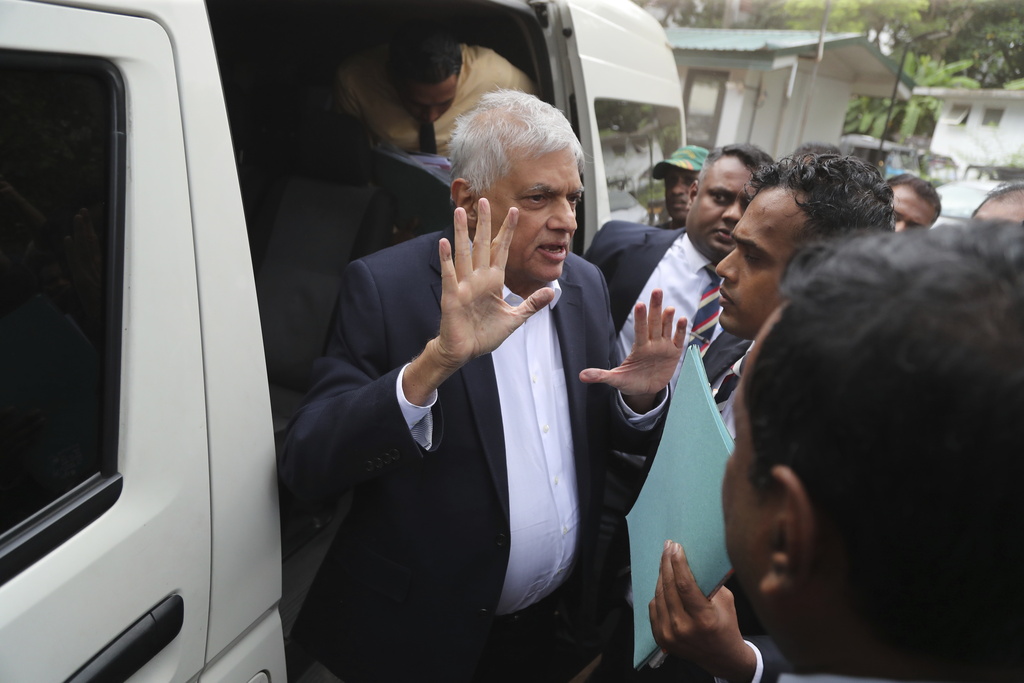 Former Sri Lankan President Ranil Wickremesinghe, center, is escorted to court by police in Colombo, Sri Lanka, Friday, Aug. 22, 2025. (AP Photo/Lahiru Harshana)