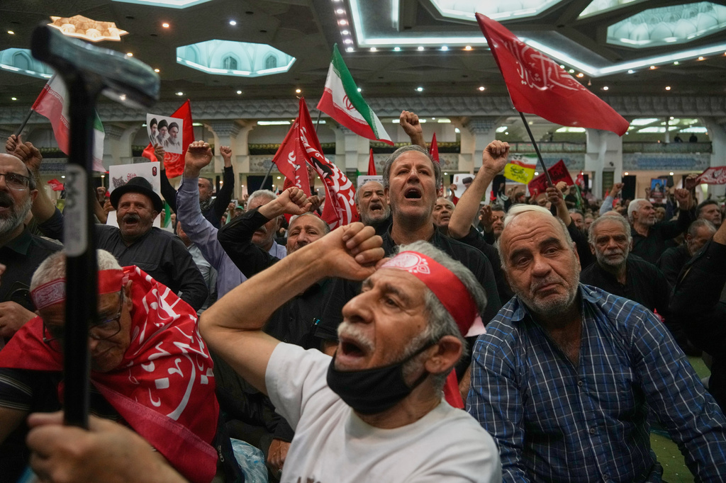 Mourners chant as they raise their fists during a gathering commemorating the late Supreme Leader Ali Khamenei at the Imam Khomeini Mosalla Grand Mosque in Tehran, Iran, Tuesday, July 14, 2026. (AP Photo/Vahid Salemi)