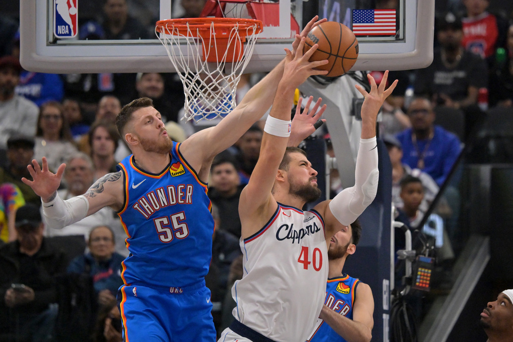 Oklahoma City Thunder center/forward Isaiah Hartenstein (55) is charged with a foul as he reaches to defend Los Angeles Clippers center Ivica Zubac during the first half of an NBA basketball game Tuesday, Nov. 4, 2025, in Los Angeles. (AP Photo/Jayne Kamin-Oncea)