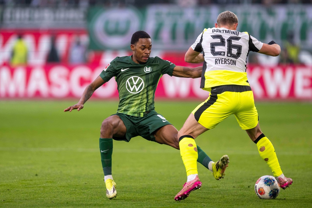Dortmund's Julian Ryerson, right, and Wolfsburg's Jeanuel Belocian fight for the ball during their German Bundesliga soccer match in Wolfsburg, Germany, Saturday, Feb. 7, 2026. (David Inderlied/dpa via AP)