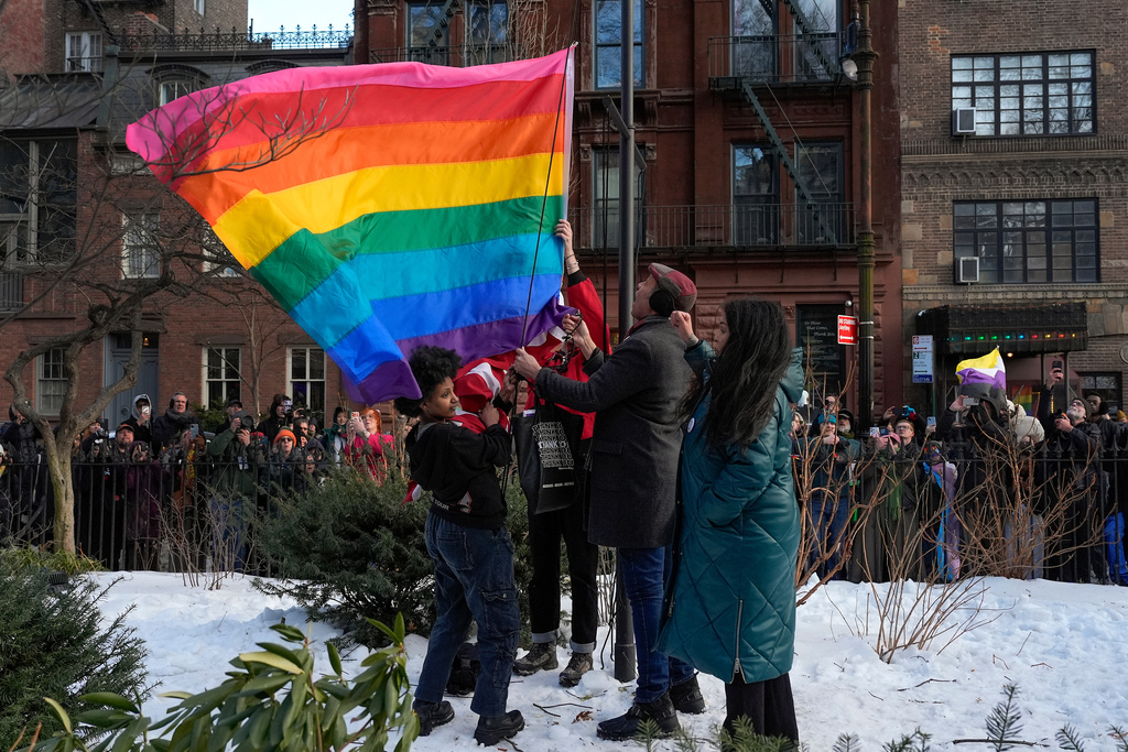 New York politicians and activists raise a rainbow flag on a pole in Christopher Park across the street from the Stonewall Inn, Thursday, Feb. 12, 2026, in New York, a few days after it was removed by the National Park Service to comply with guidance from the Trump administration. (AP Photo/Yuki Iwamura)