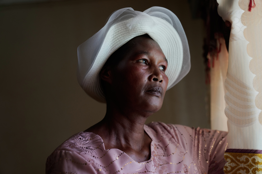 Anne Bonareri, a widow, looks out the window of her home in Kisii, Kenya, Wednesday, Nov. 26, 2025. (AP Photo/Brian Inganga)