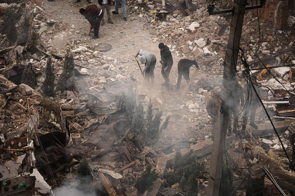 People clear the rubble at the site of an apartment buildings damaged during a Russian attack in Kyiv, Ukraine, Sunday, Sept. 28, 2025. (AP Photo/Efrem Lukatsky)