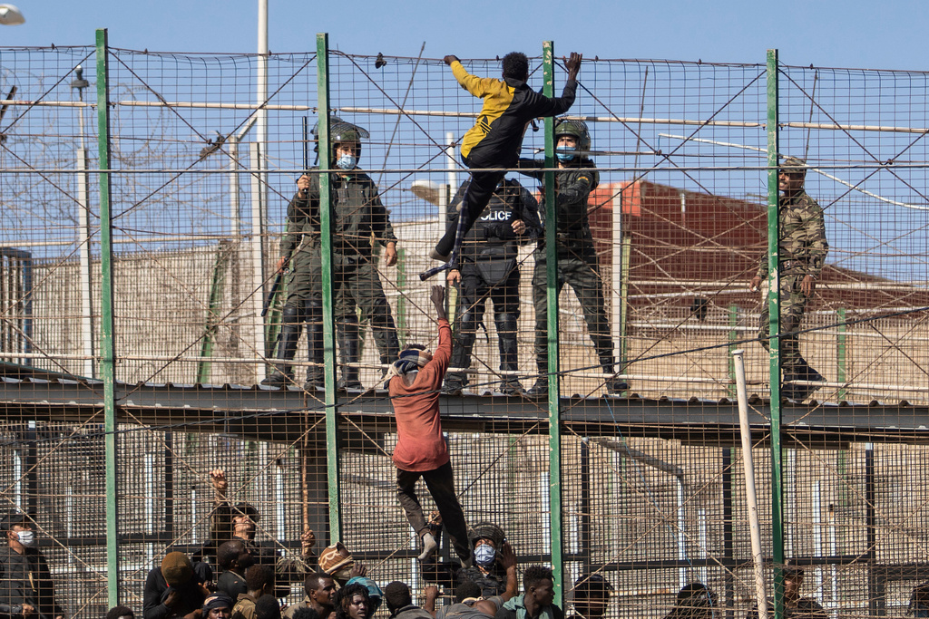 FILE - Migrants climb the fences separating the Spanish enclave of Melilla from Morocco in Melilla, Spain, Friday, June 24, 2022. (AP Photo/Javier Bernardo, File)