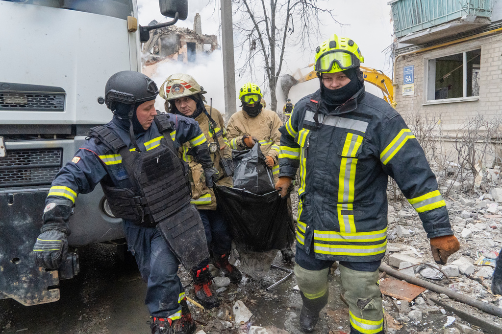 Rescuers carry a body that they extracted from under the rubble of an apartment building following Russia's missile attack in Kharkiv, Ukraine, Saturday, March 7, 2026. (AP Photo/Andrii Marienko)