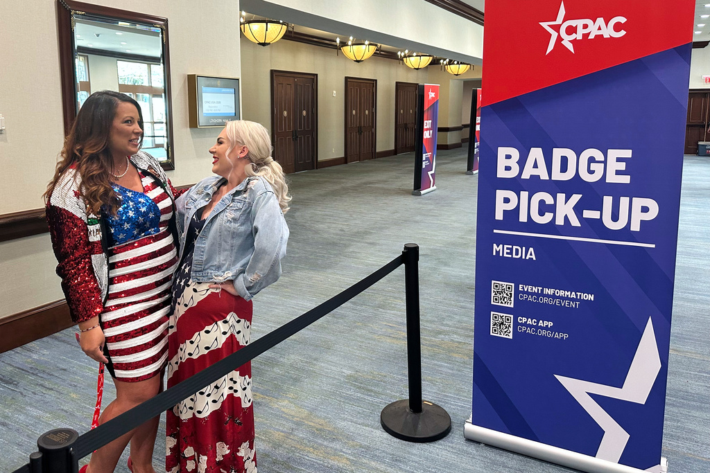 Leslie Sawyer, left, and Hilary Jackson chat in line for media credentials at the Conservative Political Action Conference in Grapevine, Texas, Wednesday, March 25, 2026, as the annual gathering of thousands of conservatives from around the country and overseas begins. Sawyer, of Redding, Calif,, is a conservative media personality with Mountaintop Media, while Jackson, of Cleveland, represents the conservative Ohio Political News. (AP Photo/Thomas Beaumont)