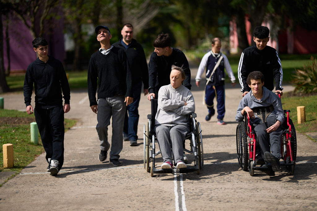 Volunteers go for a walk with residents at the Pequeño Cottolengo Don Orione, a home for people with disabilities that will be visited by Pope Leo XIV in November, in Buenos Aires, Argentina, Thursday, Sept. 24, 2026. (AP Photo/Rodrigo Abd)