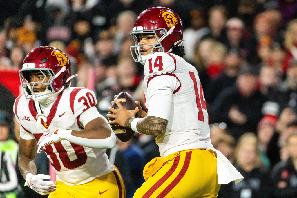 Southern California quarterback Jayden Maiava (14), flanked by running back King Miller (30) looks to pass against Nebraska during the first half of an NCAA college football game, Saturday, Nov. 1, 2025, in Lincoln, Neb. (AP Photo/Bonnie Ryan)