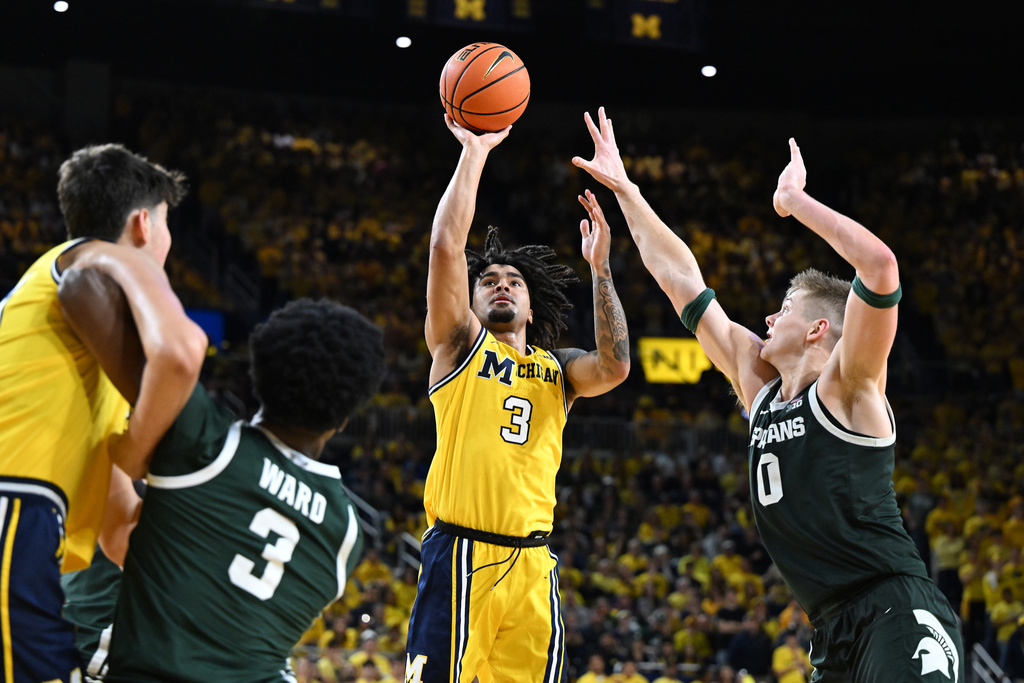 Michigan guard Elliot Cadeau (3) shoots the ball over Michigan State forward Jaxon Kohler (0) in the second half of an NCAA college basketball game in Ann Arbor, Mich., Sunday, March 8, 2026. (AP Photo/Lon Horwedel)