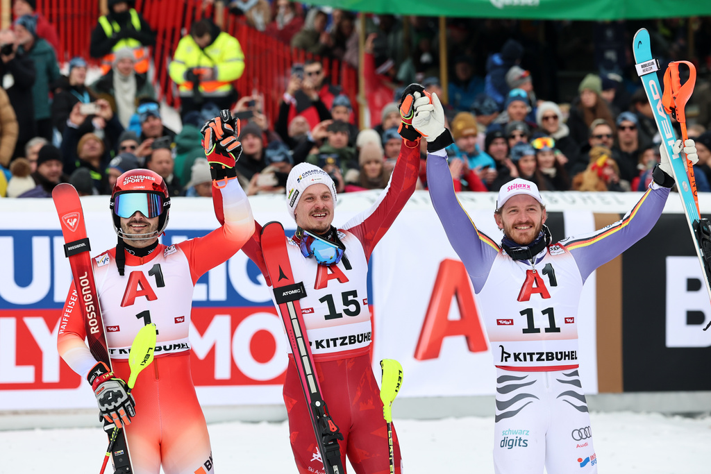 Austria's Manuel Feller, centre, winner of an alpine ski, men's World Cup slalom, poses with second placed Switzerland's Loic Meillard, left, and third placed Germany's Linus Strasser, in Kitzbuehel, Austria, Sunday, Jan. 25, 2026. (AP Photo/Marco Trovati)