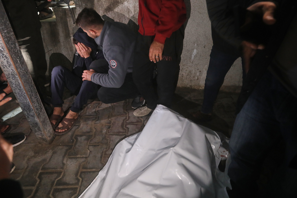 Palestinians mourn next to the bodies of people killed in an Israeli military strike, after arriving at Shifa Hospital in Gaza City, Friday, Dec. 19, 2025. (AP Photo/Yousef Al Zanoun)