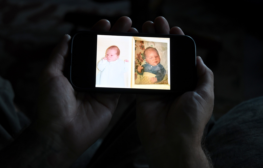 Jeremy Morrison, who says he was sent home with the wrong parents after he was born, shows what he believes is a baby photo of him, left, and of the other baby he says was switched at birth while recounting the story at his home in Colorado City, Colo., on Thursday, July 16, 2026. (AP Photo/Thomas Peipert)