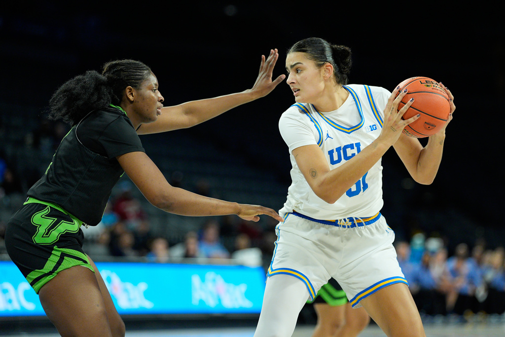 UCLA center Lauren Betts (51) drives against South Florida forward Fatou Diakite (8) during the first half of an NCAA college basketball game Saturday, Nov. 15, 2025, in Las Vegas. (AP Photo/John Locher)