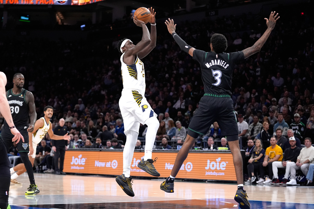 Indiana Pacers forward Pascal Siakam, center, goes up to shoot over Minnesota Timberwolves forward Jaden McDaniels (3) during the first half of an NBA basketball game, Sunday, Oct. 26, 2025, in Minneapolis. (AP Photo/Abbie Parr)