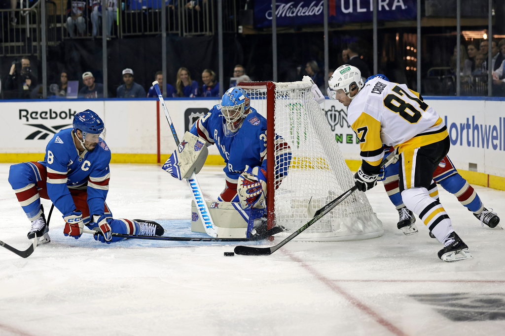 New York Rangers goaltender Igor Shesterkin and J.T. Miller (8) defend a shot by Pittsburgh Penguins center Sidney Crosby in the first period of an NHL hockey game, Tuesday, Oct. 7, 2025, in New York. (AP Photo/Adam Hunger)