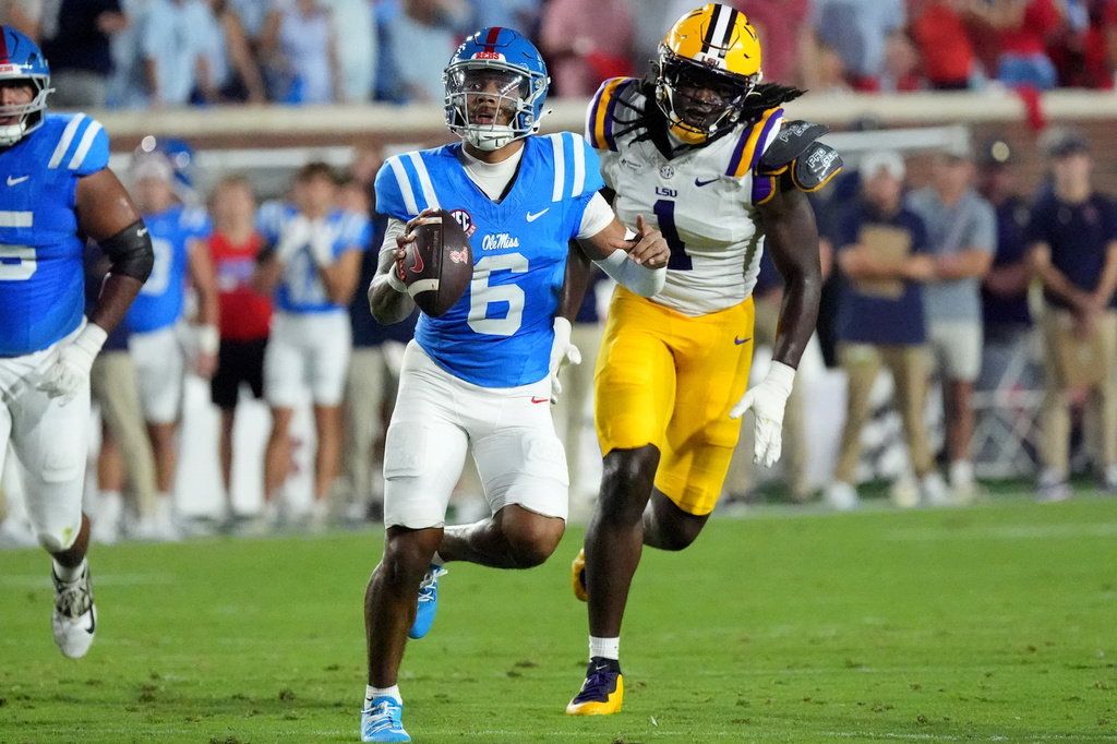 Mississippi quarterback Trinidad Chambliss (6) is pursued by LSU defensive end Princewill Umanmielen (1) during the first half of an NCAA college football game in Oxford, Miss., Saturday, Sept. 19, 2026. (AP Photo/Rogelio V. Solis)