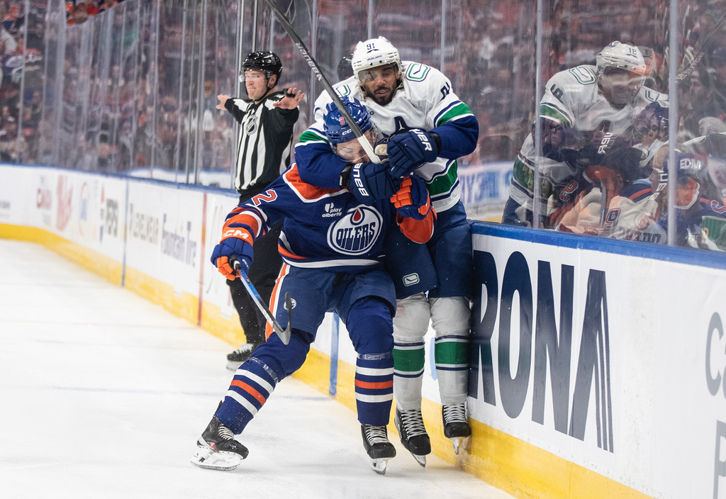 Vancouver Canucks' Evander Kane (91) grabs Edmonton Oilers' Vasily Podkolzin (92) around the head during the third period of an NHL hockey game in Edmonton, Alberta, Saturday, Oct. 11, 2025. (Jason Franson/The Canadian Press via AP)