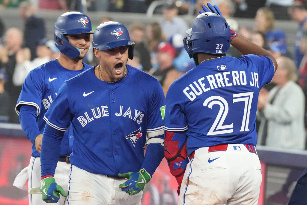 Toronto Blue Jays' George Springer (centre) celebrates his two-run home run against the Boston Red Sox with Vladimir Guerrero Jr. (27) during sixth inning MLB baseball action in Toronto on Thursday Sept. 25, 2025. (Chris Young/The Canadian Press via AP)