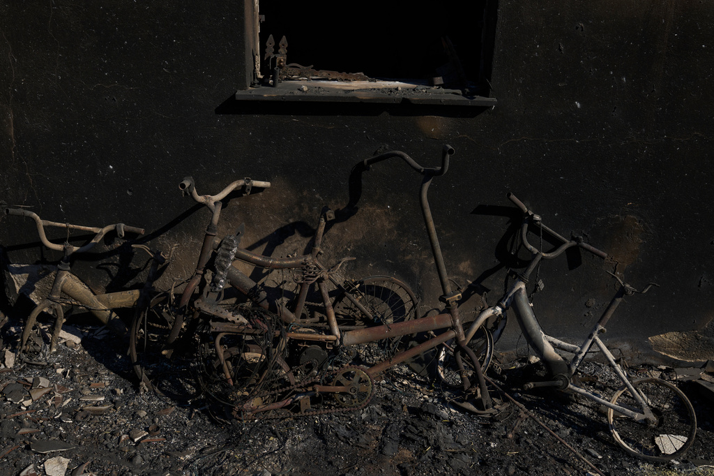 Burned bicycles lean against the wall of a house destroyed by a wildfire in Porto Germeno, northwest of Athens, Greece, Monday, Aug. 3, 2026. (AP Photo/Petros Giannakouris)
