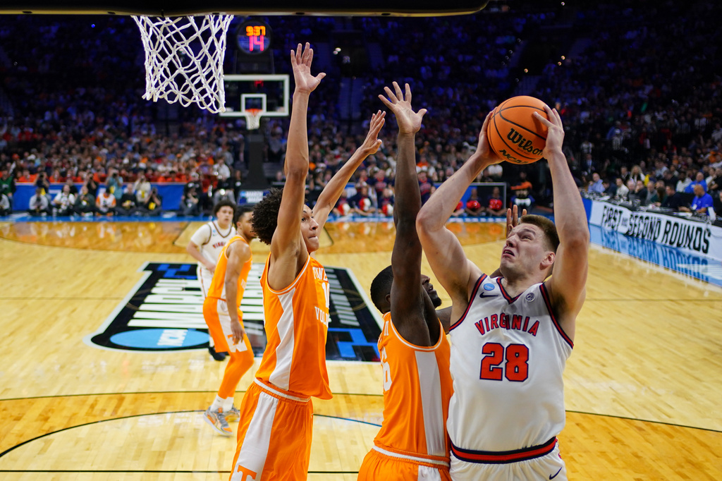 FILE - Virginia's Thijs de Ridder, right, goes up for a shot against Tennessee's Felix Okpara, center, and Nate Ament during the first half in the second round of the NCAA college basketball tournament, March 22, 2026, in Philadelphia. (AP Photo/Matt Slocum, File)