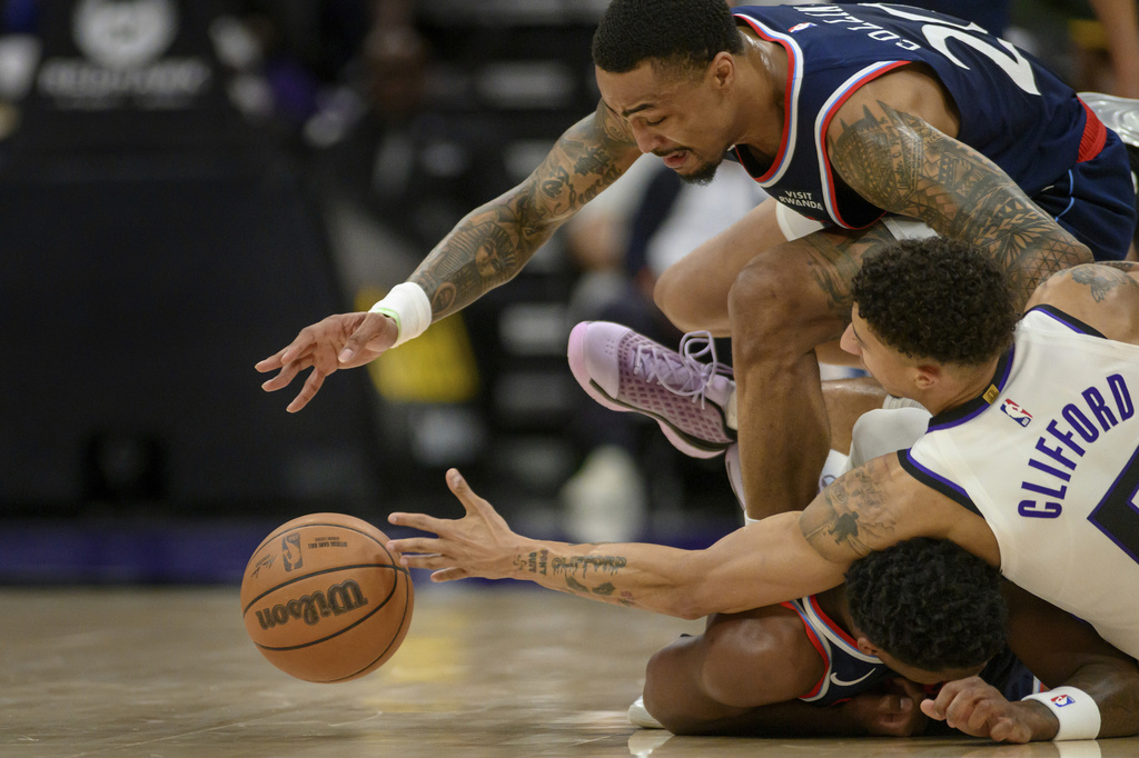 Los Angeles Clippers forward John Collins, top, and guard Bennedict Mathurin, bottom, battle for a loose ball with Sacramento Kings guard Nique Clifford during the second half of an NBA basketball game in Sacramento, Calif., Sunday, April 5, 2026. (AP Photo/Randall Benton)