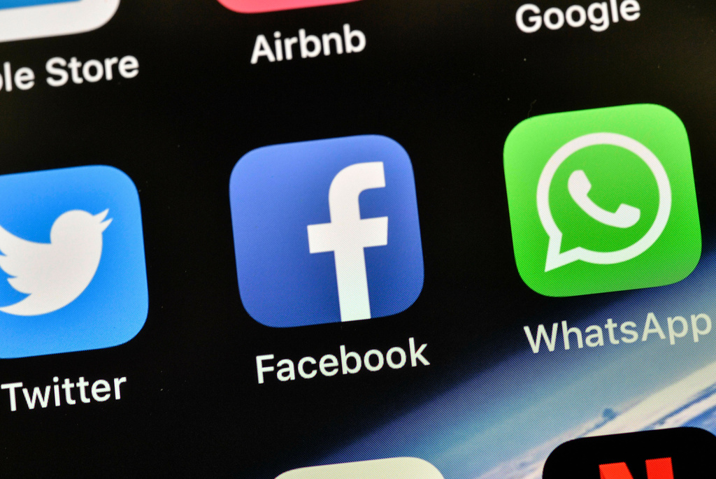 FILE - In this Thursday, Nov. 15, 2018 file photo the icons of Facebook and WhatsApp are pictured on an iPhone in Gelsenkirchen, Germany. (AP Photo/Martin Meissner,File)