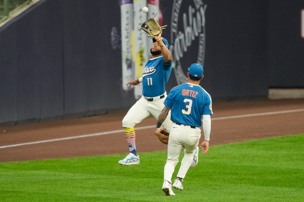 Milwaukee Brewers left fielder Jackson Chourio (11) catches a pop fly hit by Atlanta Braves' Ozzie Albies as Brewers third baseman Joey Ortiz (3) looks on during the fourth inning of a baseball game against Friday, Aug. 21, 2026, in Milwaukee. (AP Photo/Kayla Wolf)