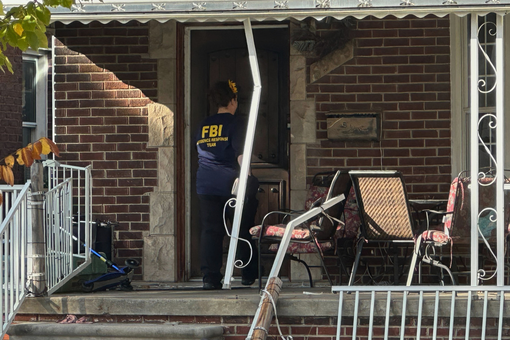 An FBI agent enters a home in a Dearborn, Mich., neighborhood on Friday, Oct. 31, 2025. (AP Photo/Mike Householder)