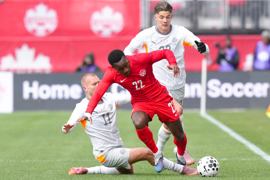 Canada's Richie Laryea, center, gets past Iceland's Jon Dagur Thorsteinsson, left, during an international friendly soccer match in Toronto, Saturday March 28, 2026. (Chris Young/The Canadian Press via AP)