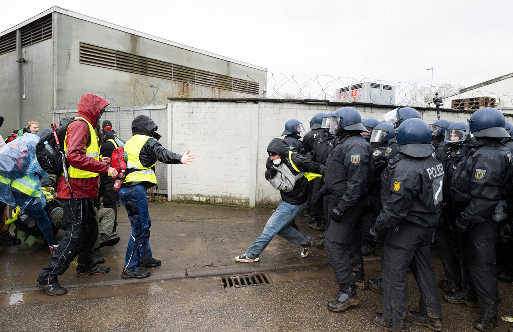 Police officers stand near the assembly hall and block demonstrators' access during a protest against the founding of a new AfD youth organization, in Hesse, Germany, Saturday, Nov. 29, 2025. (Boris Roessler/dpa via AP)