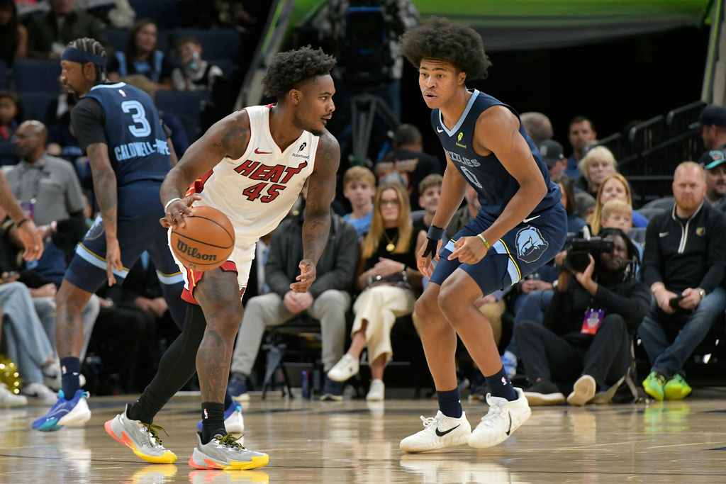 Miami Heat guard Davion Mitchell (45) handles the ball against Memphis Grizzlies forward Jaylen Wells (0) in the first half of an NBA basketball game Friday, Oct. 24, 2025, in Memphis, Tenn. (AP Photo/Brandon Dill)