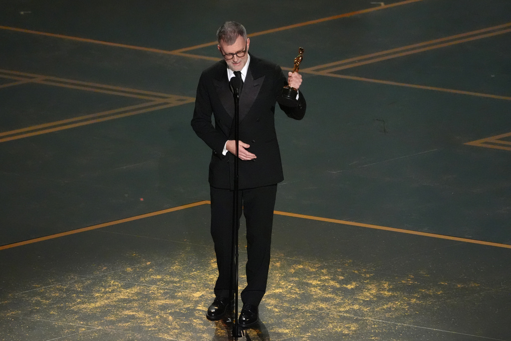 Paul Thomas Anderson accepts the award for writing (adapted screenplay) for "One Battle After Another" during the Oscars on Sunday, March 15, 2026, at the Dolby Theatre in Los Angeles. (AP Photo/Chris Pizzello)