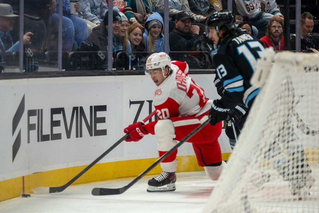 Detroit Red Wings defenseman Albert Johansson (20) go for the puck along with Utah Mammoth left wing Brandon Tanev (13) during the first period of an NHL hockey game, Wednesday, Feb. 4, 2026, in Salt Lake City. (AP Photo/Rick Egan)