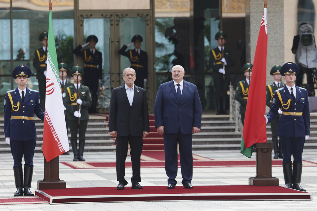 In this photo, released by Belarusian Presidential Press Service, Belarusian President Alexander Lukashenko, center right, and Iranian President Masoud Pezeshkian, center left, attend a welcome ceremony prior to their talks in Minsk, Belarus, Wednesday, Aug. 20, 2025. (Belarusian Presidential Press Service via AP)