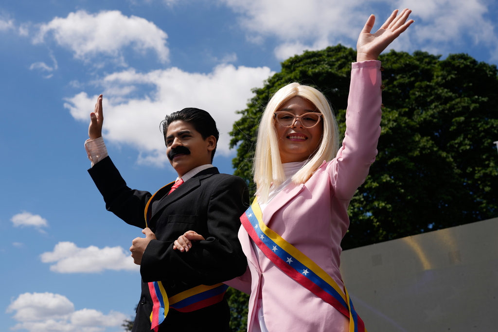 Performers on stilts dressed as former Venezuelan President Nicolas Maduro and his wife Cilia Flores wave during a march by government supporters calling for their release after U.S. forces captured them, in Caracas, Venezuela, Friday, Jan. 9, 2026. (AP Photo/Ariana Cubillos)