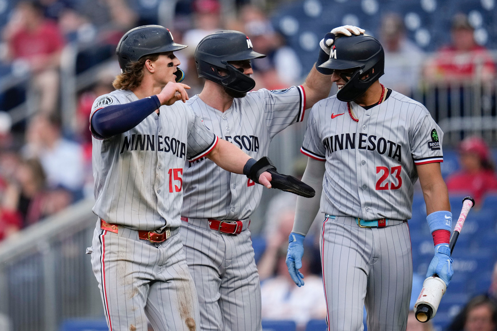 Minnesota Twins' Luke Keaschall (15) and Kody Clemens, center, celebrate with Royce Lewis (23) after scoring against the Washington Nationals on a double hit by Brooks Lee during the second inning of a baseball game, Tuesday, May 5, 2026, in Washington. (AP Photo/Jess Rapfogel)