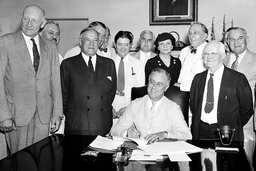 FILE - President Franklin Roosevelt signs the Social Security Bill in Washington Aug. 14, 1935. (AP Photo, File)