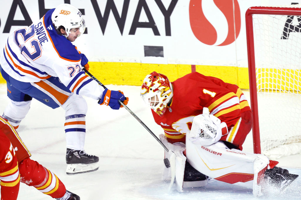 Edmonton Oilers' Matt Savoie, left, is stopped by Calgary Flames goalie Devin Cooley during third period NHL hockey action in Calgary, Alberta, Wednesday, Feb. 4, 2026. (Larry MacDougal/The Canadian Press via AP)