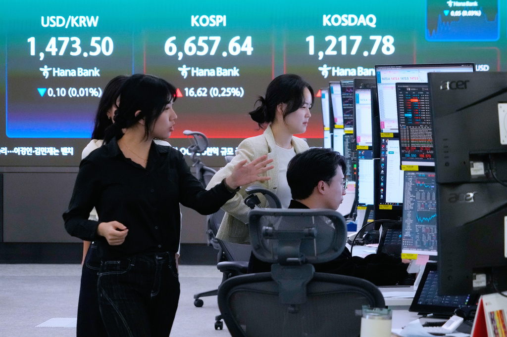 Currency traders work near a screen showing the Korea Composite Stock Price Index (KOSPI), top center, and the foreign exchange rate between U.S. dollar and South Korean won, top center left, at the foreign exchange dealing room of the Hana Bank headquarters in Seoul, South Korea, Wednesday, April 29, 2026. (AP Photo/Ahn Young-joon)
