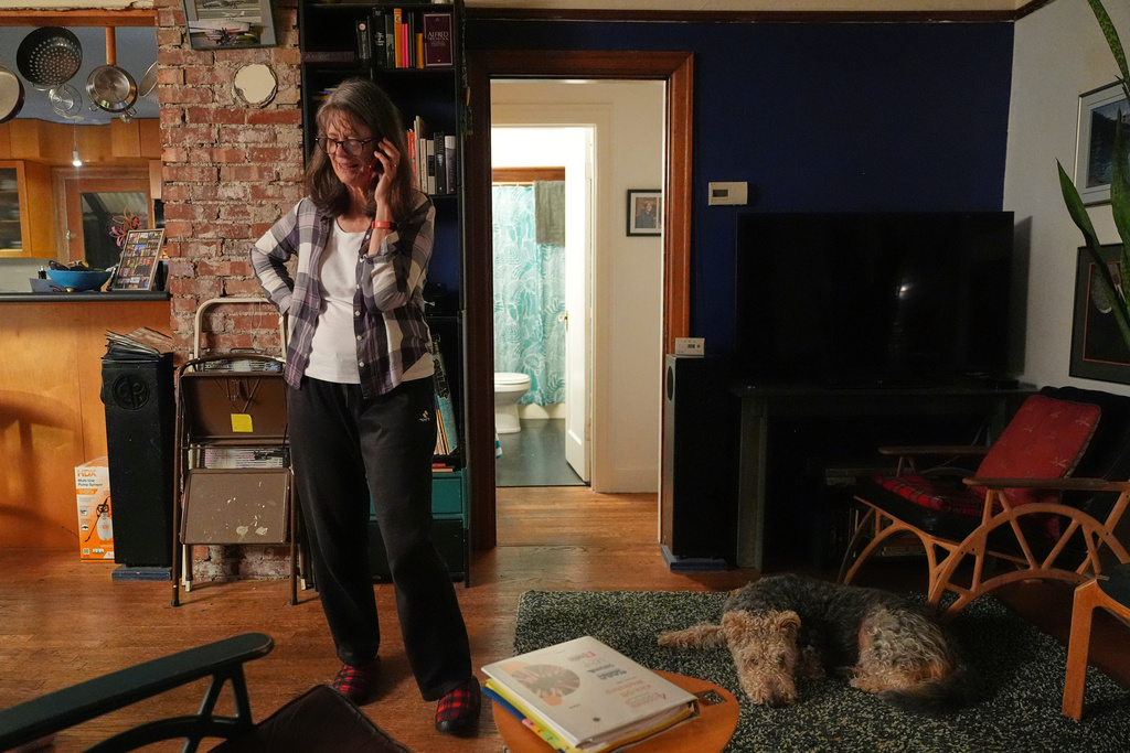 Mary E. Brunkow speaks on the phone during an interview after winning a Nobel Prize in medicine for part of her work on peripheral immune tolerance, in Seattle, Monday, Oct. 6, 2025. Next to her is her dog Zelda. (AP Photo/Lindsey Wasson)