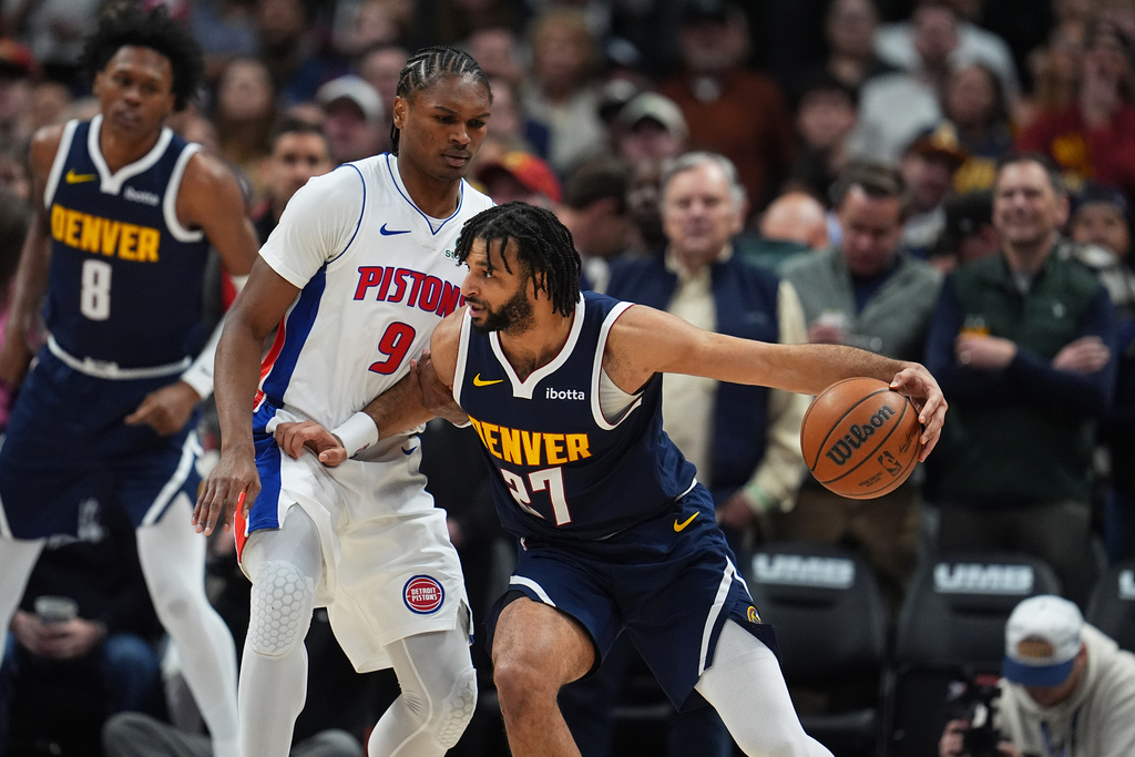 Denver Nuggets guard Jamal Murray, right, drives past Detroit Pistons guard Ausar Thompson in the first half of an NBA basketball game Tuesday, Jan. 27, 2026, in Denver. (AP Photo/David Zalubowski)