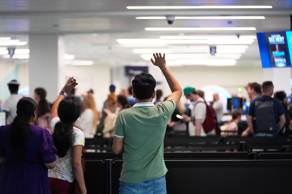 People wave goodbye to departing passengers at a TSA security screening checkpoint at the Jacksonville International Airport in Jacksonville, Fla., Monday, March 16, 2026. (AP Photo/Gerald Herbert)