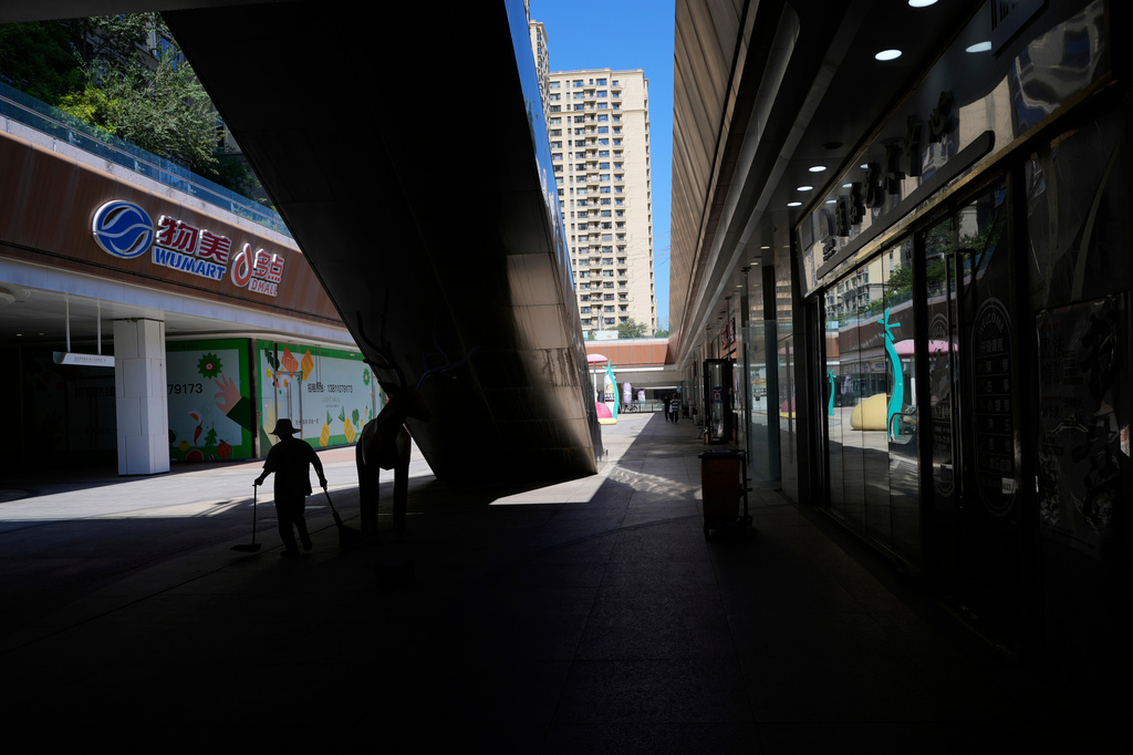 FILE -A worker collects trash in a partially shuttered Evergrande commercial complex, on the day Hong Kong Stock Exchange delisted the Chinese property developer China Evergrande, in Beijing, China, Aug. 25, 2025. (AP Photo/Mahesh Kumar A., File)