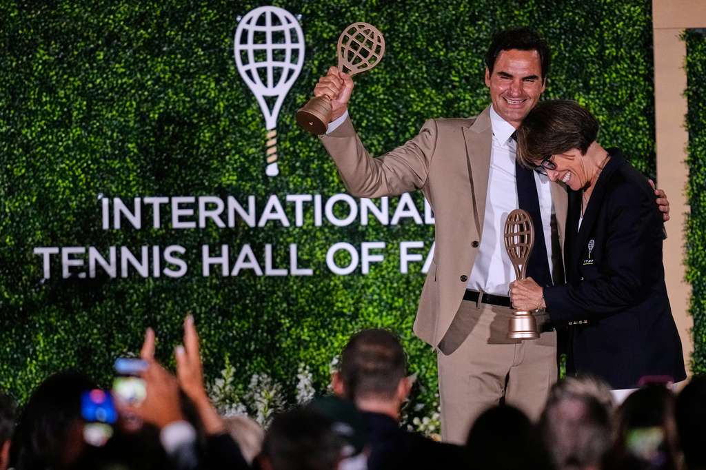 Roger Federer embraces Mary Carillo, who was honored as a broadcast contributor, during the induction ceremony at the International Tennis Hall of Fame, Saturday, Aug. 29, 2026, in Newport, R.I. (AP Photo/Charles Krupa)