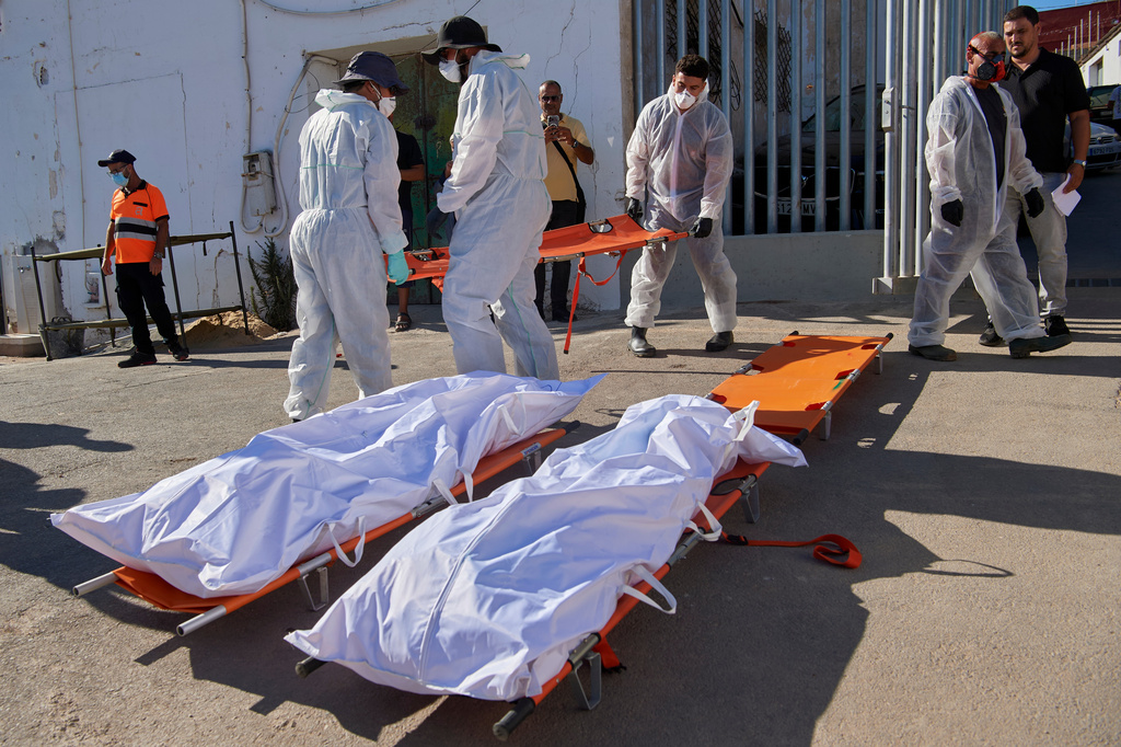Funeral workers gather the bodies of migrants who died while trying to cross from Morocco into the Spanish exclave of Ceuta, Friday, Aug. 21, 2026. (AP Photo/Antonio Sempere)
