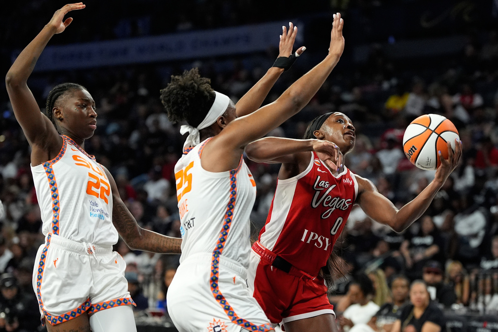 Las Vegas Aces guard Jackie Young (0) drives against Connecticut Sun's Kennedy Burke during the second half of a WNBA basketball game Thursday, Aug. 20, 2026, in Las Vegas. (AP Photo/John Locher)