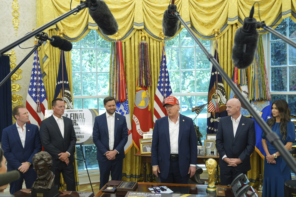 President Donald Trump speaks with reporters as Homeland Security Secretary Kristi Noem, from right, FIFA President Gianni Infantino, Vice President JD Vance, Richard Grenell, president of the Kennedy Center Board of Trustees and Andrew Giuliani listen in the Oval Office of the White House, Friday, Aug. 22, 2025, in Washington. (AP Photo/Jacquelyn Martin)