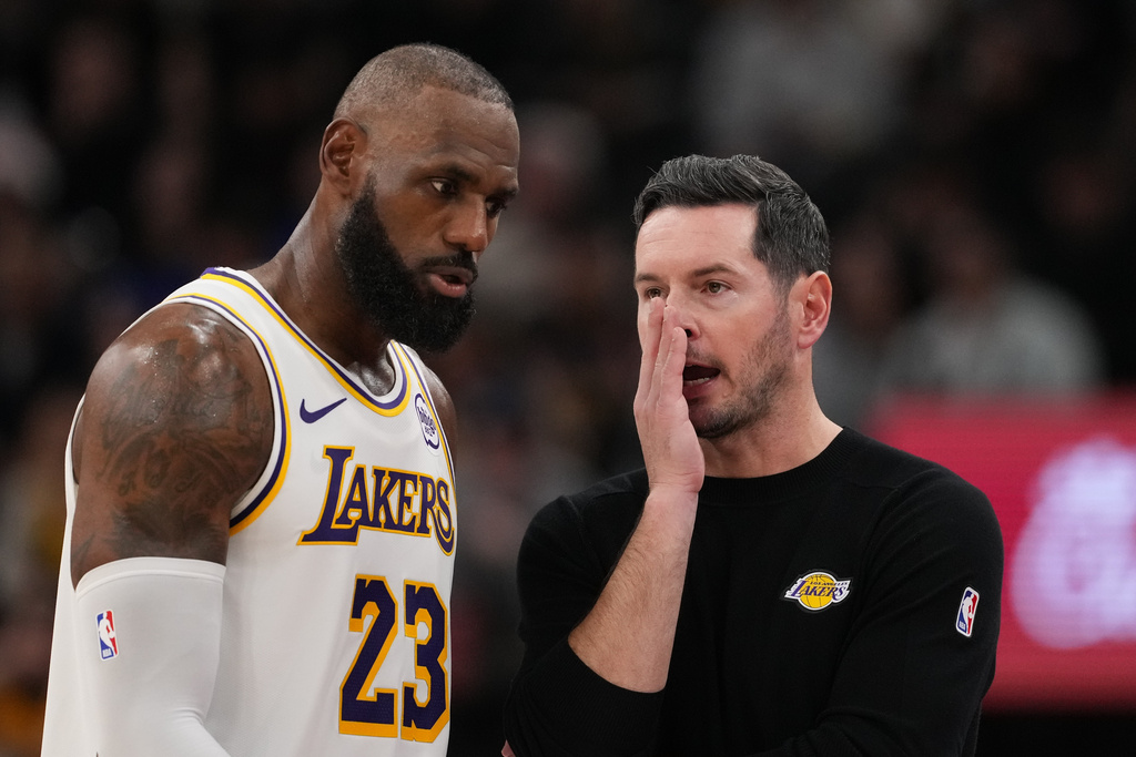 Los Angeles Lakers Head Coach JJ Redick, right, talks to Lebron James during the second half of an NBA basketball game against the Los Angeles Clippers Saturday, Dec. 20, 2025, in Inglewood, Calif. (AP Photo/Jae C. Hong)