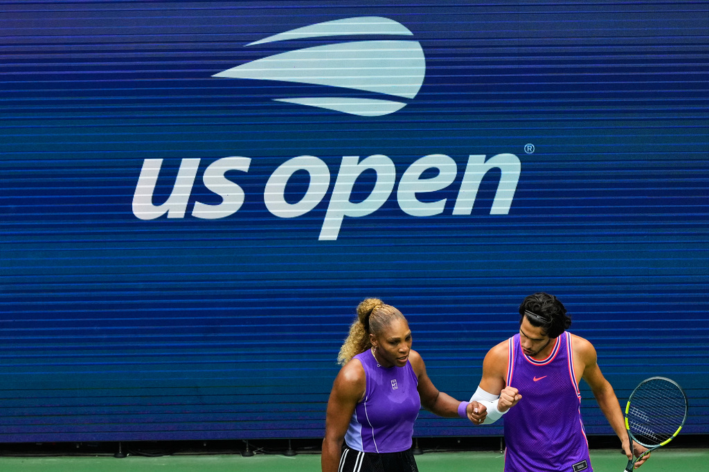 Serena Williams, of the United States, and Carlos Alcaraz, of Spain, react during a mixed doubles match at the U.S. Open tennis championships, Tuesday, Aug. 25, 2026, in New York. (AP Photo/Yuki Iwamura)